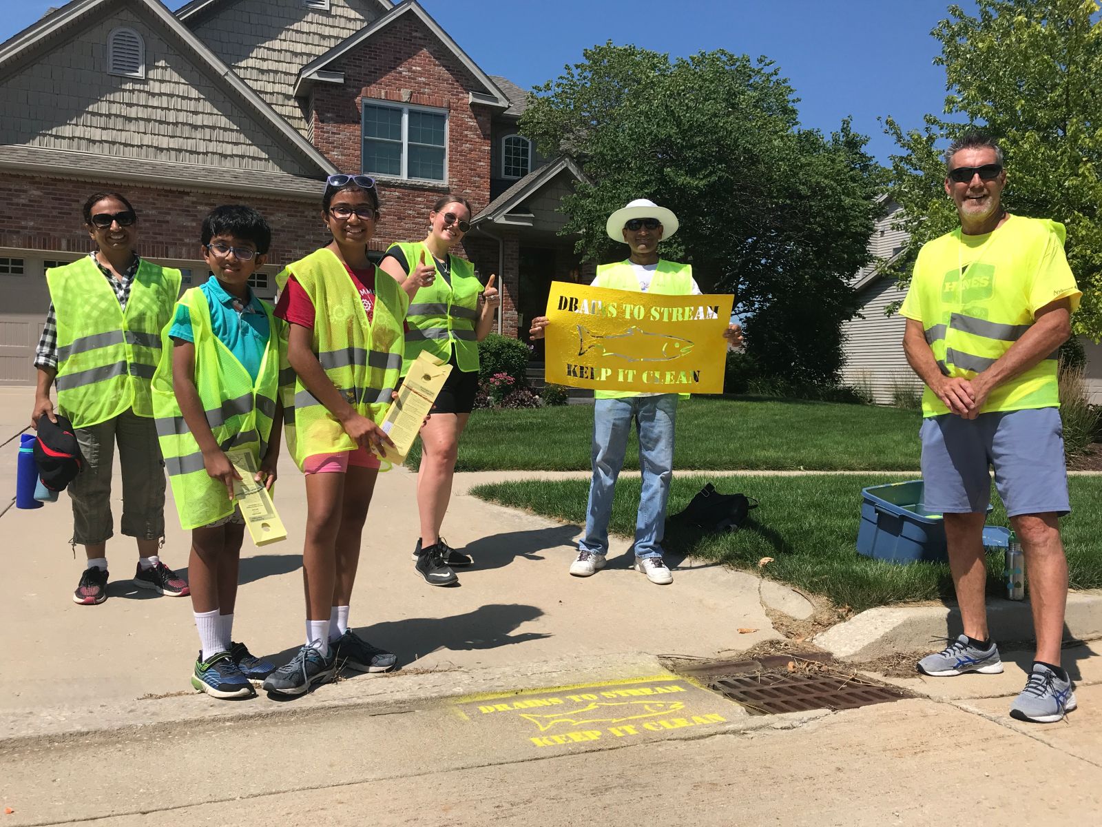 storm drain stenciling volunteers posing next to drain